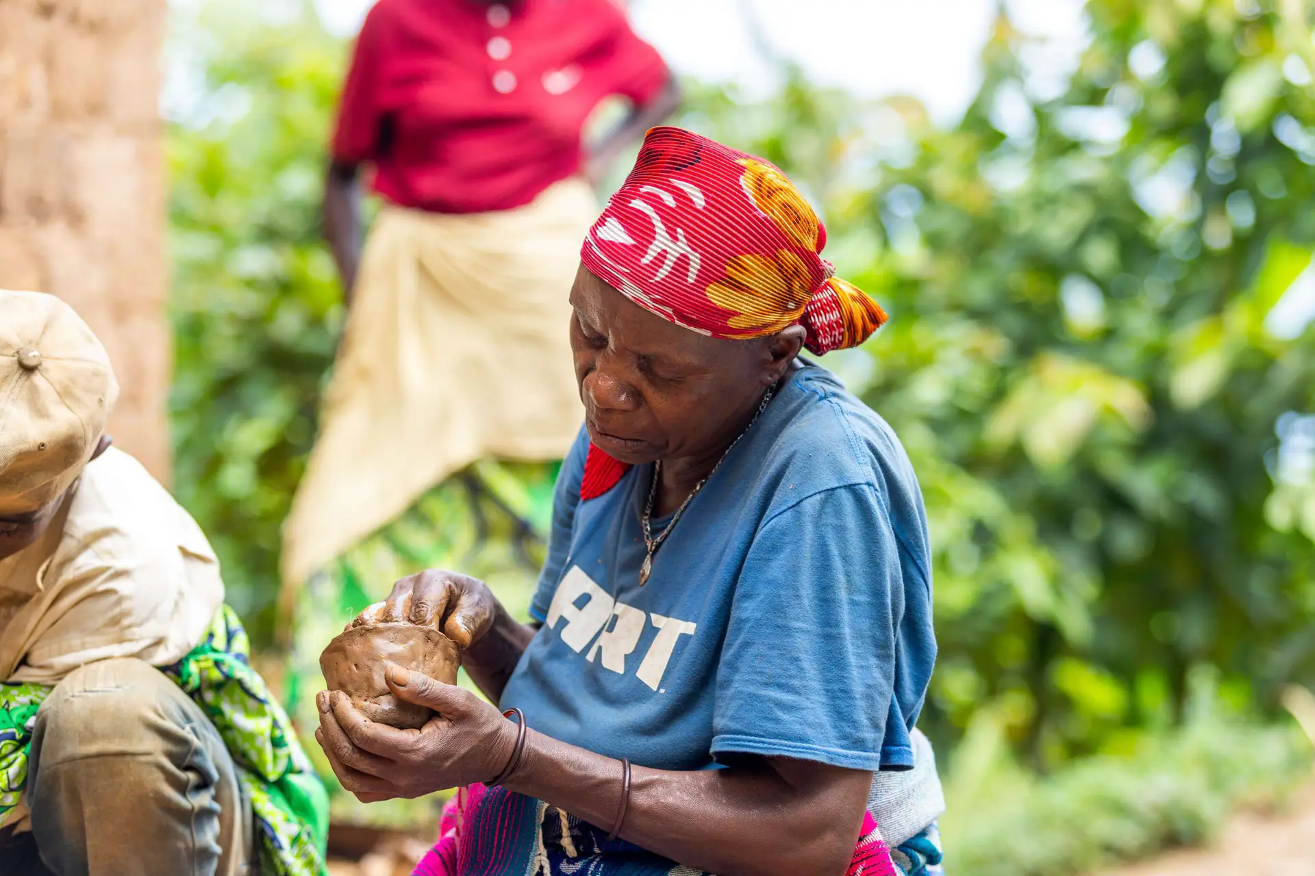 A woman shaping a clay pot by hand