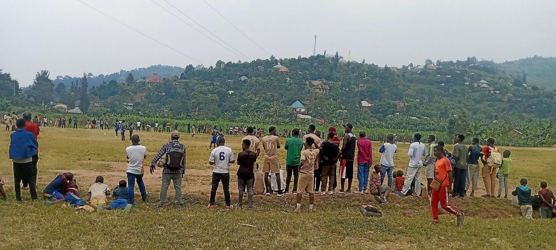 Community members and young fans watching from the sideline