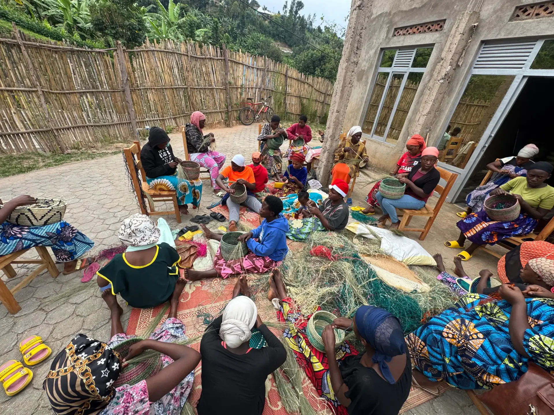A courtyard full of women weaving baskets together